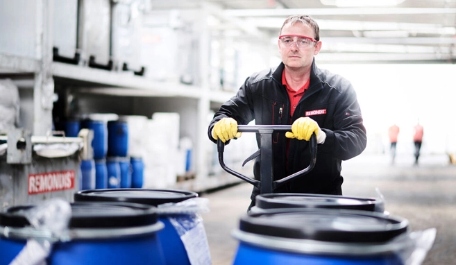 Mitarbeiter von REMONDIS Italia transportiert Spannringfässer auf einem Hubwagen im Sonderabfall-Zwischenlager