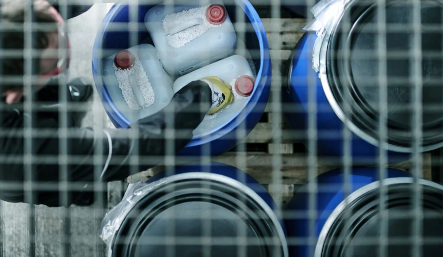 Vista dall'alto di fusti con anello di tenuta con dei contenitori dei rifiuti immagazzinati al loro interno.